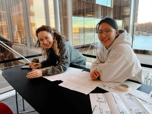 Two team members discussing the Timeline project at a work table.