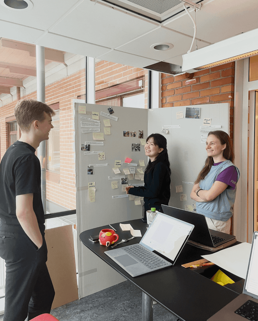 Timeline team discussing research and interface sketches around a whiteboard.