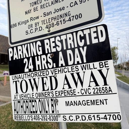 Close-up of a sign reading Parking restricted 24 hrs a day, unauthorized vehicles will be towed away.