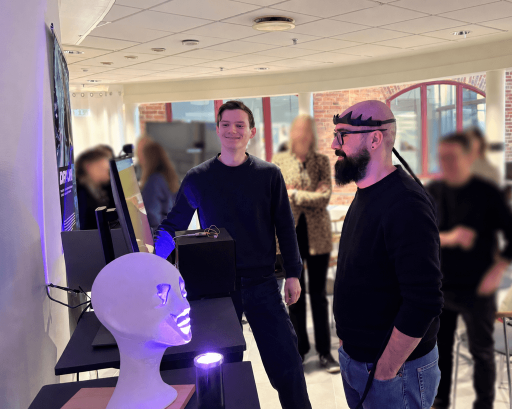 Visitors examining the Drion prototype at a design exhibition.