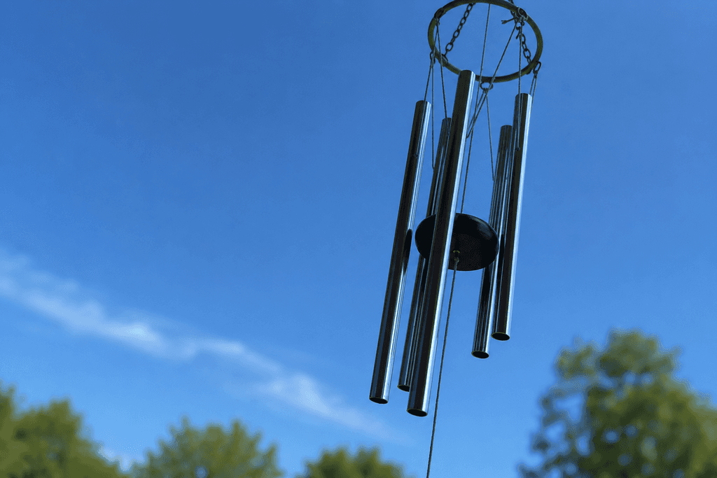 A wind chime suspended against a blue sky.
