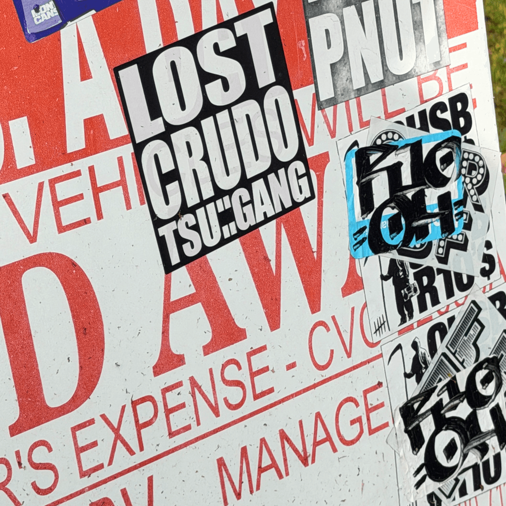 Layered red, black, and white towing and parking notices.