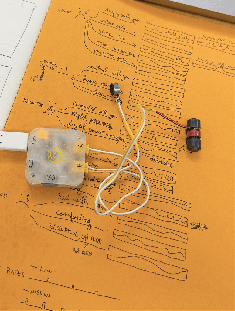 Early haptic prototype with motors and wiring laid out over a diagram.