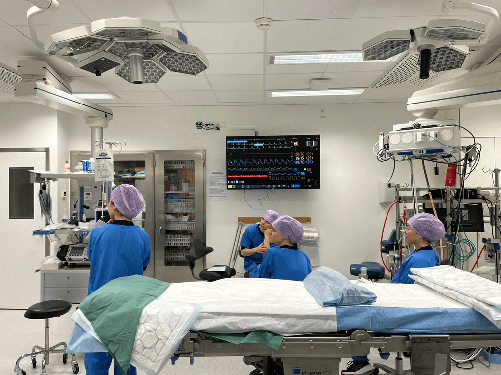 Clinical staff caring for a patient in an intensive care unit.