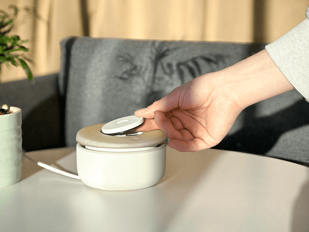 The Chime recorder resting on a table as a hand operates its disc.