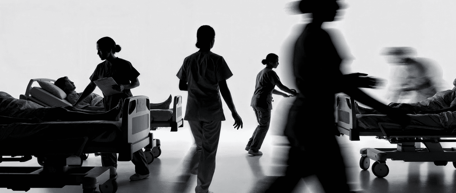 Healthcare staff working around patients in a busy hospital ward.